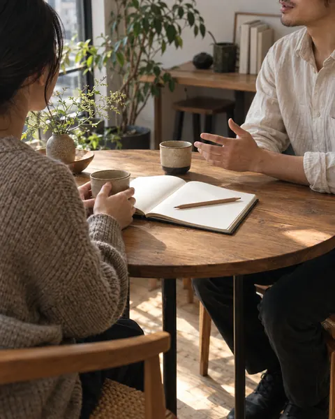 窓辺の丸いテーブルで、コーヒーを飲みながらご相談をうかがう様子